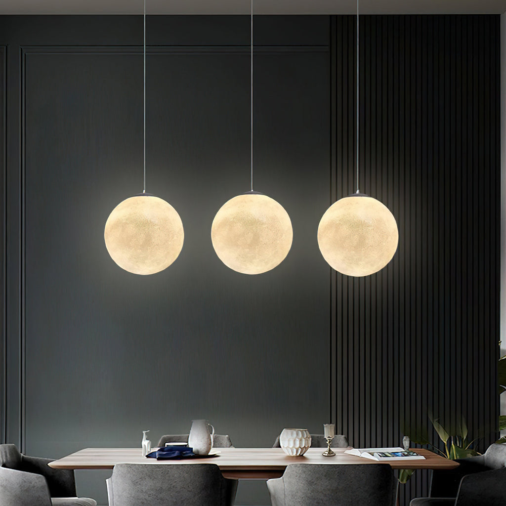 Three evenly spaced Clérachic spheres in warm white hang over a dining table, against a dark slatted wall.