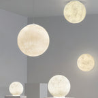 A group of Clérachic spheres in cream and white at several heights, the largest in front, with smaller ones lit below.