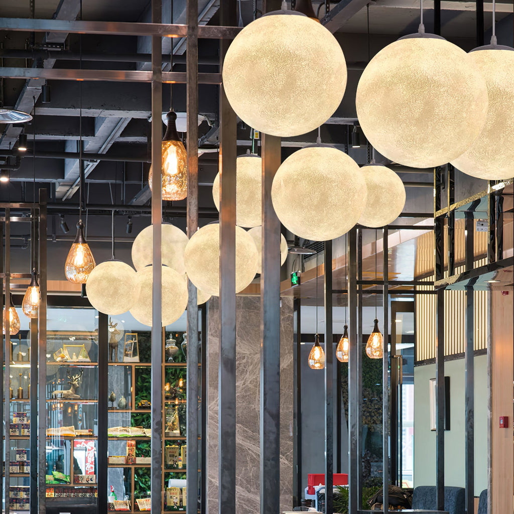 Warm Clérachic spheres of varied sizes hang beside amber glass pendants in front of steel framing and shelves.