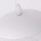 Underside of the white canopy and clear cord grip where the cord meets the shell of this Clérachic pendant.
