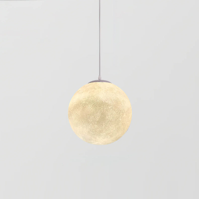 The smallest Clérachic sphere pendant, lit warm cream on a thin cord, against a light grey backdrop.