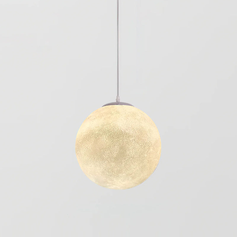 Compact lit Clérachic sphere pendant, textured and cream-coloured, hanging from a thin white cord on light grey.