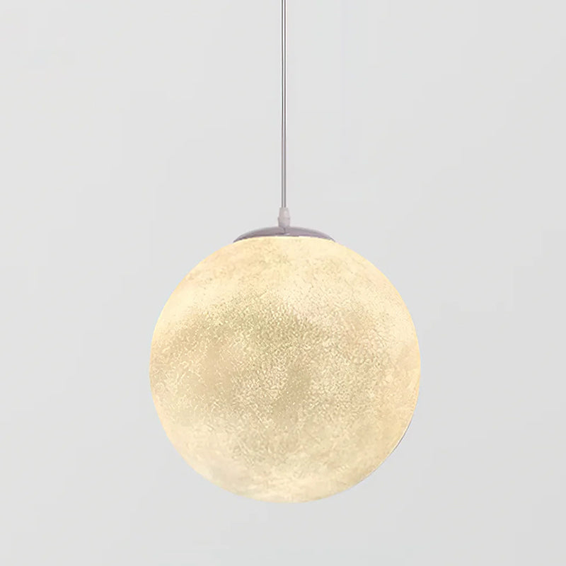 The largest Clérachic sphere pendant, lit warm cream, nearly filling the frame on its thin cord against pale grey.