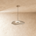 Clérachic rippling resin pendant in white, lit softly from within, hanging from a chrome canopy by plaster walls