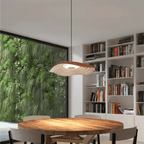 Clérachic terracotta and white rippled resin pendant above a round timber dining table, shelves and greenery behind