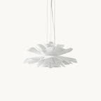 Clérachic pendant with layered white acrylic petals forming a lotus shape, hung on slim cables against a plain white backdrop.