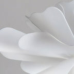 Close view of the smooth, curved white acrylic petals on this Clérachic pendant.