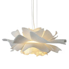 Clérachic white petal pendant with layered petals and a warm glow below, hung on slim cables on a white backdrop.