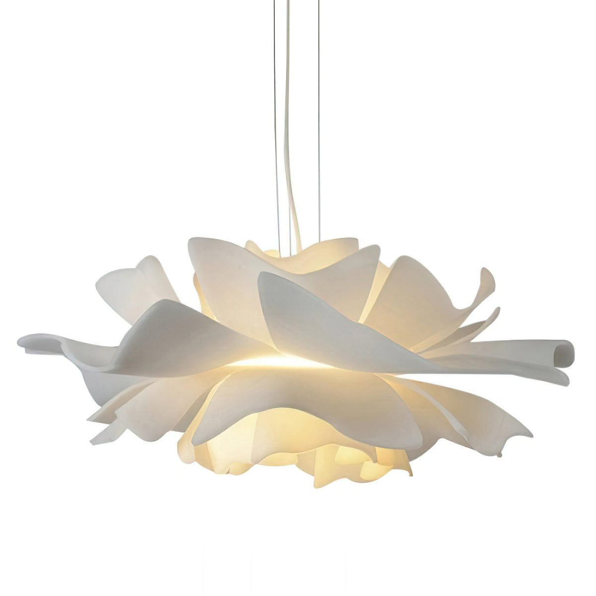 Clérachic white petal pendant with layered petals and a warm glow below, hung on slim cables on a white backdrop.
