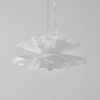 Clérachic white petal pendant with its lowest petals in sharp focus, hung on clear cables against a pale grey backdrop.