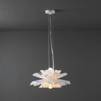 Clérachic white petal pendant with a white ceiling canopy, lit, with a bulb glowing inside the petals, on a dark grey wall.