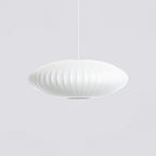 Against a grey backdrop, a broad, flat Clérachic pendant in white shows pale vertical ribs and a rounded rim.
