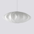 A very wide Clérachic pendant with a diamond-patterned white shade hangs on a grey backdrop, its rim thin and light.