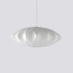 On pale grey, a medium-sized Clérachic pendant with a diamond criss-cross shade hangs from a thin white cord.
