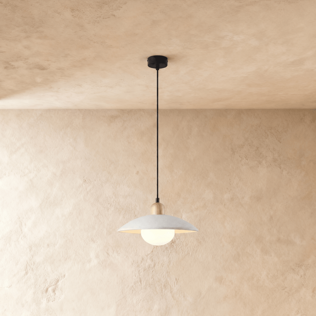 Clérachic pendant light in white, the saucer shade and opal glass diffuser glowing below a plaster ceiling.