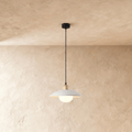 Clérachic pendant light in white, the saucer shade and opal glass diffuser glowing below a plaster ceiling.