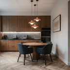 Clérachic orange pendant lights, a cluster of three, glowing above a round dining table in a walnut kitchen.