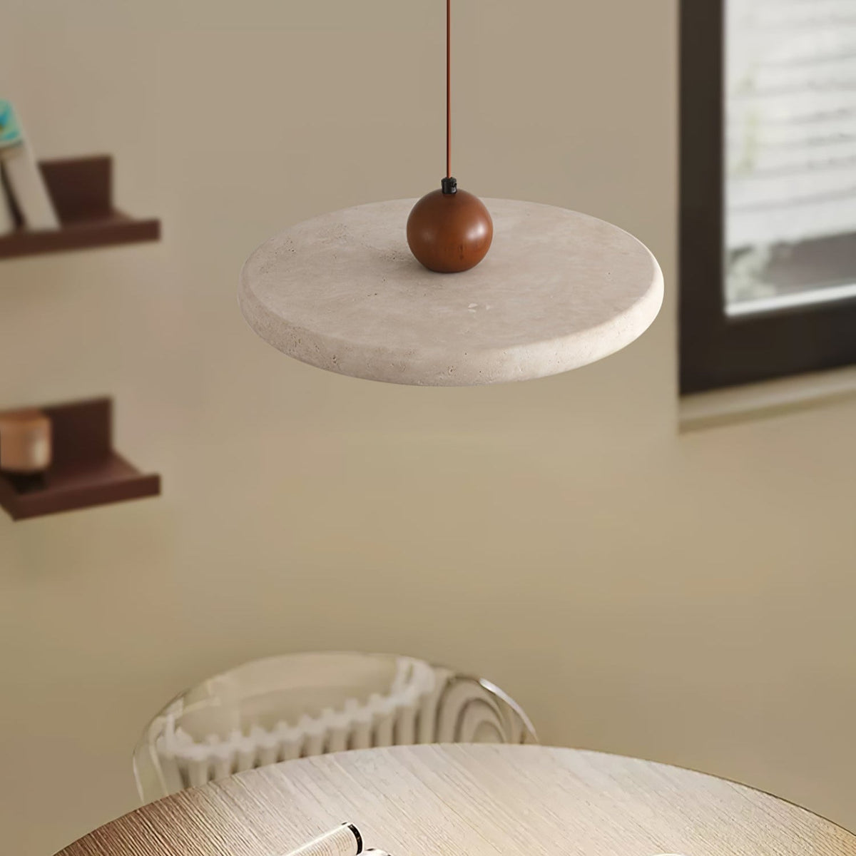 A cream stone-look disc and wooden bead of this Clérachic pendant seen from below, with shelves and a framed print behind.