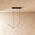 Clérachic black zig-zag LED pendant with a single bar on slim cables from a rectangular ceiling plate, on limewashed plaster.