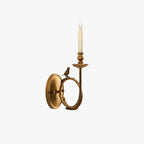 Clérachic's brass wall sconce cropped close on a white background, the bird perched where the ring meets the backplate.
