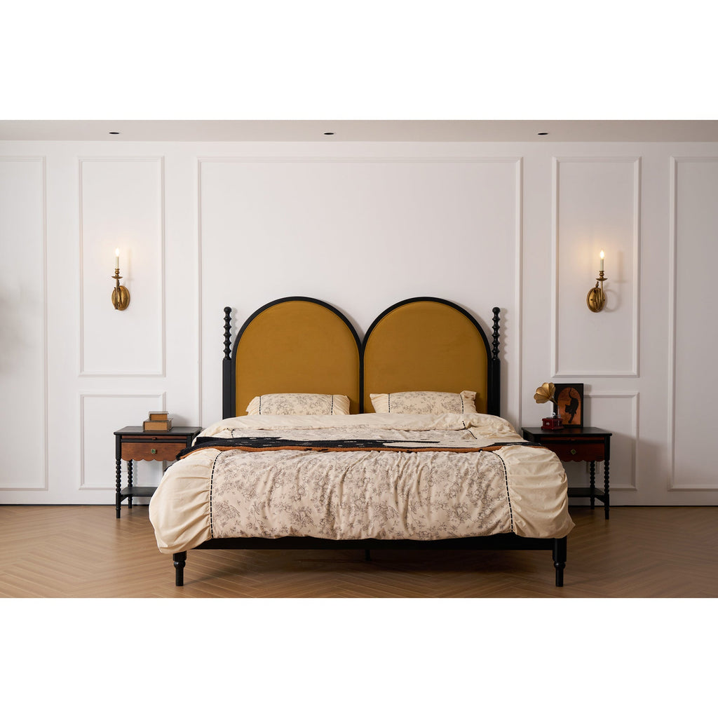 Clérachic sconces flank a panelled wall above a mustard headboard and cream bedding, both candle bulbs lit.