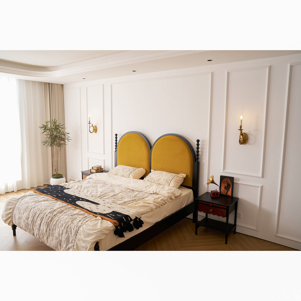 The Clérachic sconce mounted near the bedroom doorway, its warm light visible across the room with the bed beyond.