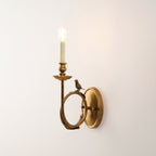 Clérachic's sconce glowing warmly on a plain wall, captured from a slightly lower side angle than the other close-ups.
