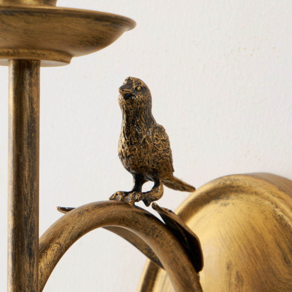 Clérachic's cast bird detail shown close-up, perched on the ring with the distressed antique brass finish visible.