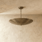 Clérachic perforated disc pendant light in vintage brass, shown from a slightly closer studio angle overhead.