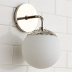 Clérachic Petal-Cap Opal Globe Wall Sconce in polished nickel, one head, the backplate mirroring the tile behind it.
