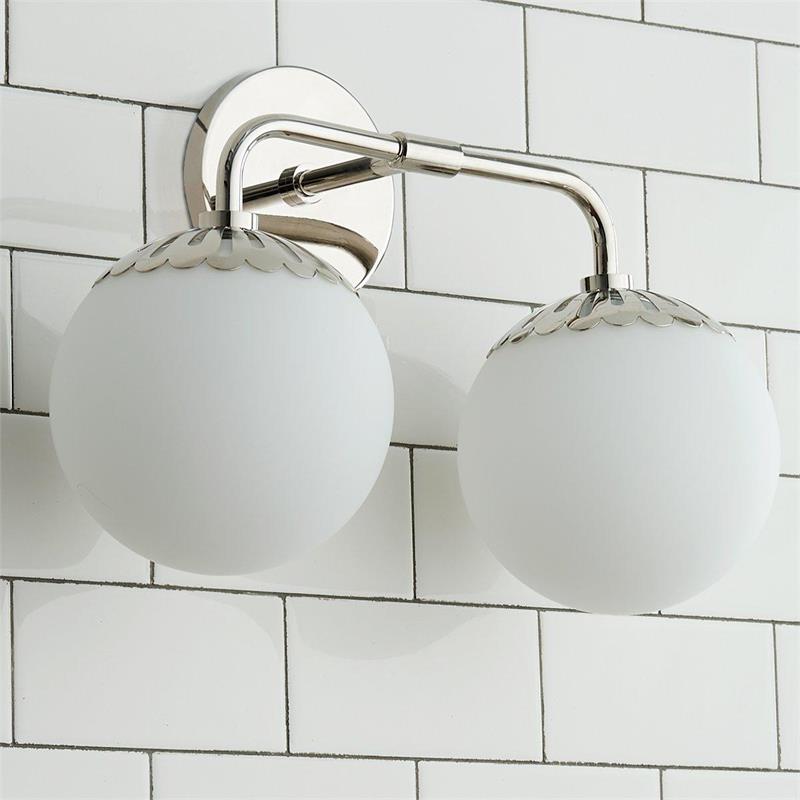 Two-head Clérachic Petal-Cap Opal Globe Wall Sconce in polished nickel, seen from below against white tile.