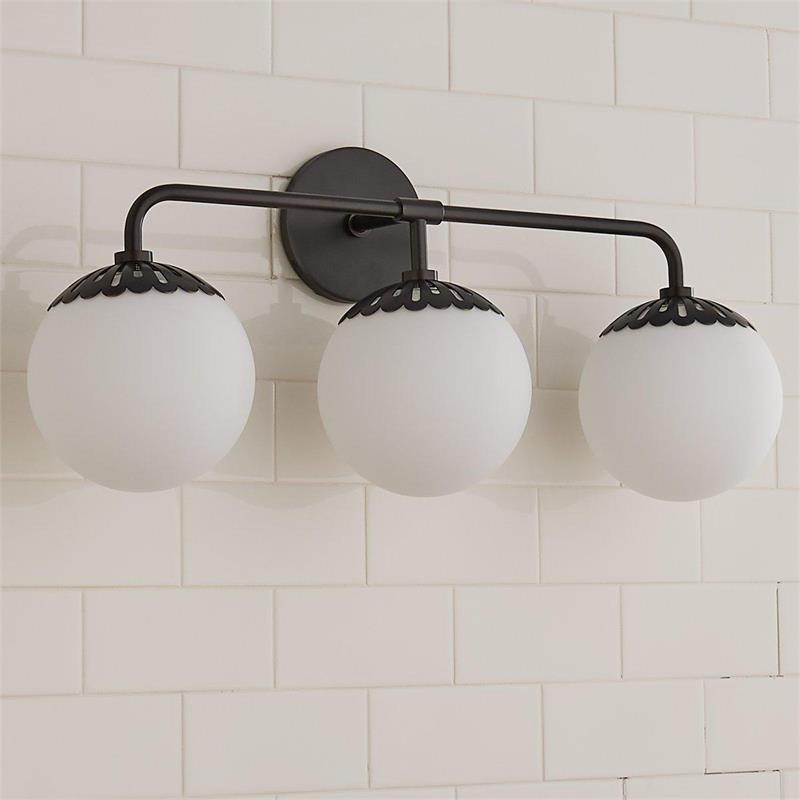 Clérachic Petal-Cap Opal Globe Wall Sconce in black, three heads spanning a white-tiled bathroom wall.