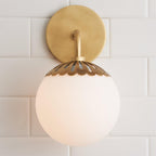 Head-on view of the brass Clérachic Petal-Cap Opal Globe Wall Sconce, round backplate centred behind the globe.