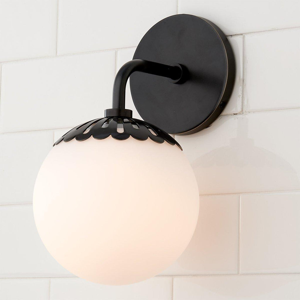 Black Clérachic Petal-Cap Opal Globe Wall Sconce photographed close from the side on white tile.