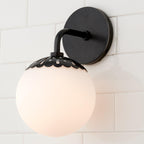 Black Clérachic Petal-Cap Opal Globe Wall Sconce photographed close from the side on white tile.