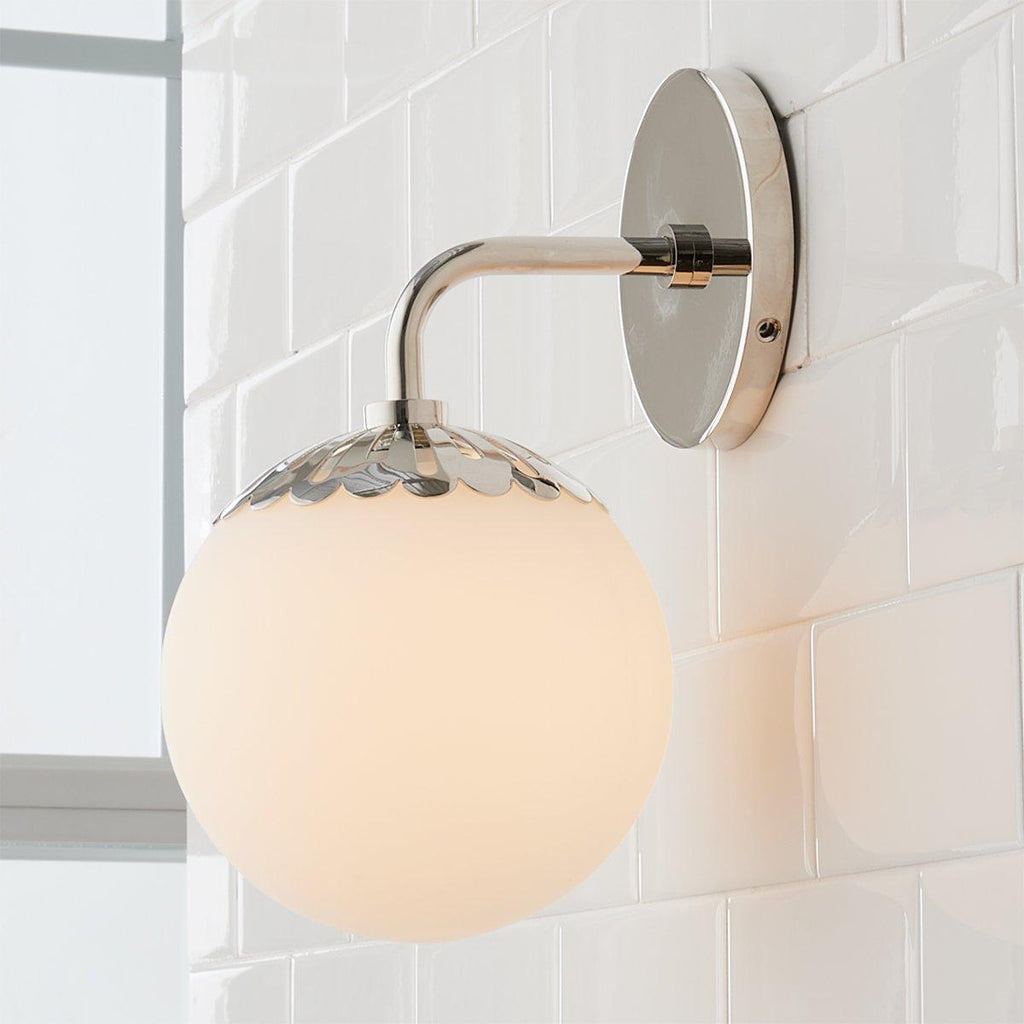 Nickel Clérachic Petal-Cap Opal Globe Wall Sconce lit by window light on glossy white tile, single head.