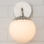 Head-on view of the nickel Clérachic Petal-Cap Opal Globe Wall Sconce, mirror-finish backplate behind the globe.
