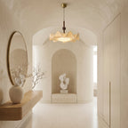 This Clérachic pendant hangs in an arched, plastered hallway with a round mirror, a floating shelf and a sculpture in a niche.