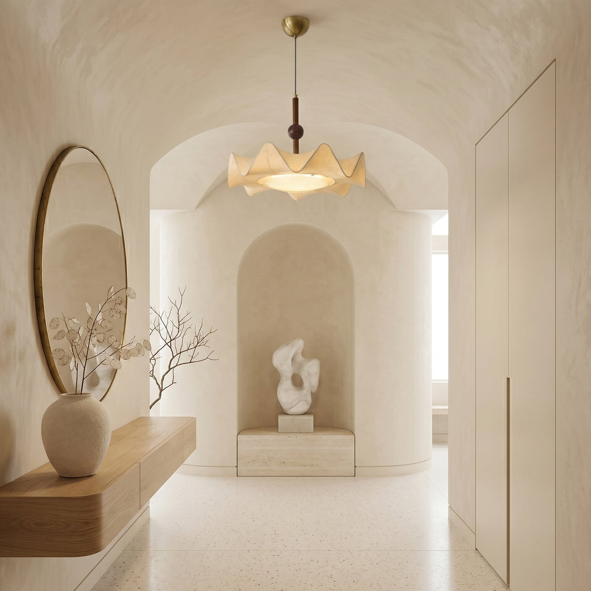 This Clérachic pendant hangs in an arched, plastered hallway with a round mirror, a floating shelf and a sculpture in a niche.