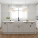 Clérachic petal pendants hung as a pair above a white kitchen island with a farmhouse sink and a black tap.