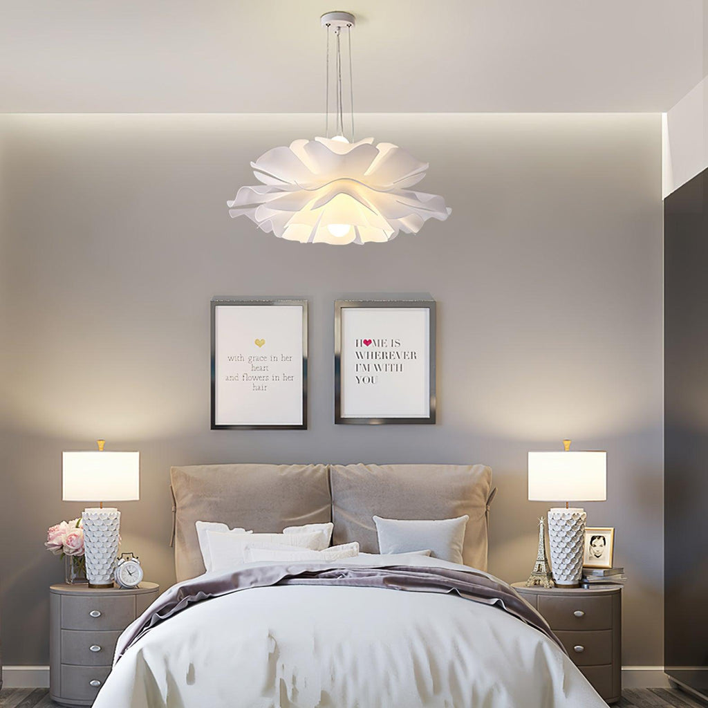 Clérachic bloom pendant above a bed flanked by matching table lamps and two framed quote prints.