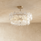 Clérachic brass semi-flush ceiling light ringed with clear ribbed glass flowers and a frosted glass base, on a limewash ceiling.