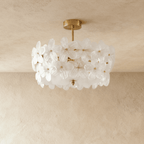 Clérachic brass ceiling light with frosted white glass flowers around a frosted glass base, hung from a short stem below plaster.