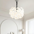 Lit Clérachic Petal Sphere Chandelier hung above an arched doorway in a room with crown moulding and a window.