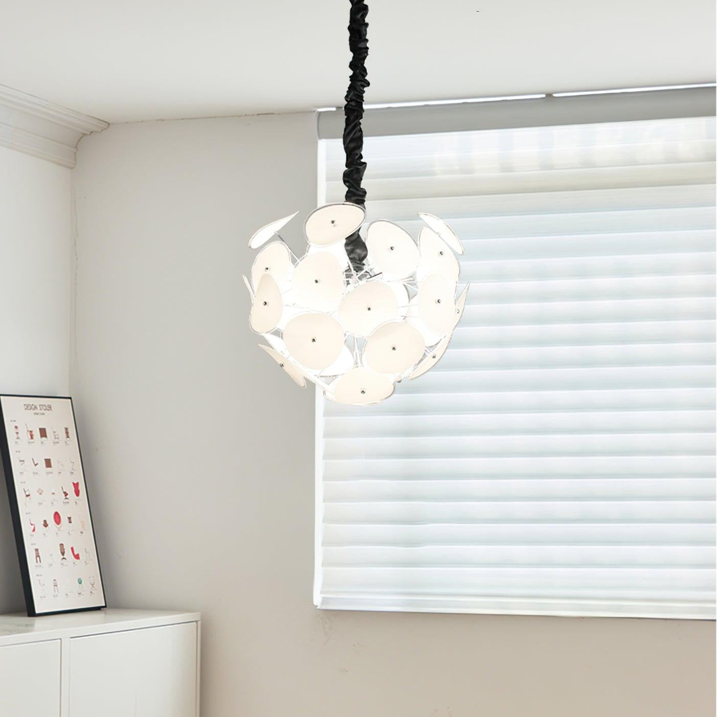 Lit Clérachic Petal Sphere Chandelier over a bedroom corner with mustard curtains and a pleated cone floor lamp.