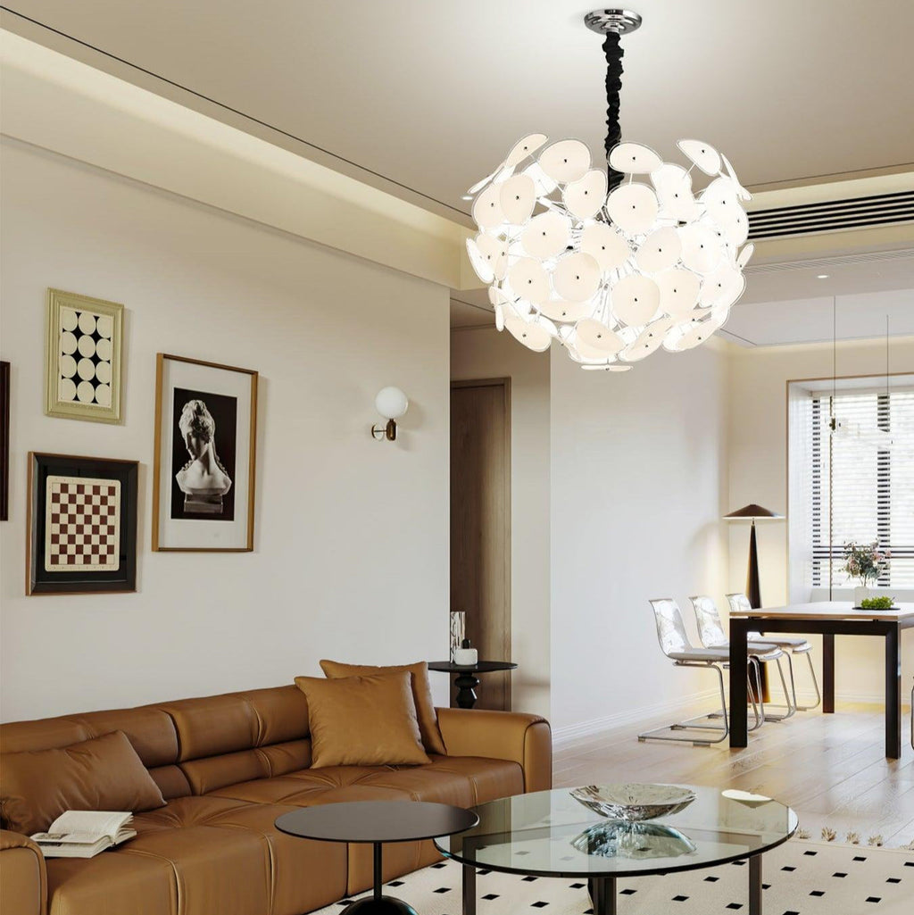 Lit Clérachic Petal Sphere Chandelier in a living room corner beside floor-to-ceiling windows over the city.