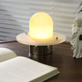 Clérachic Petrified table lamp lit close, amber glow rising through the stone shade.