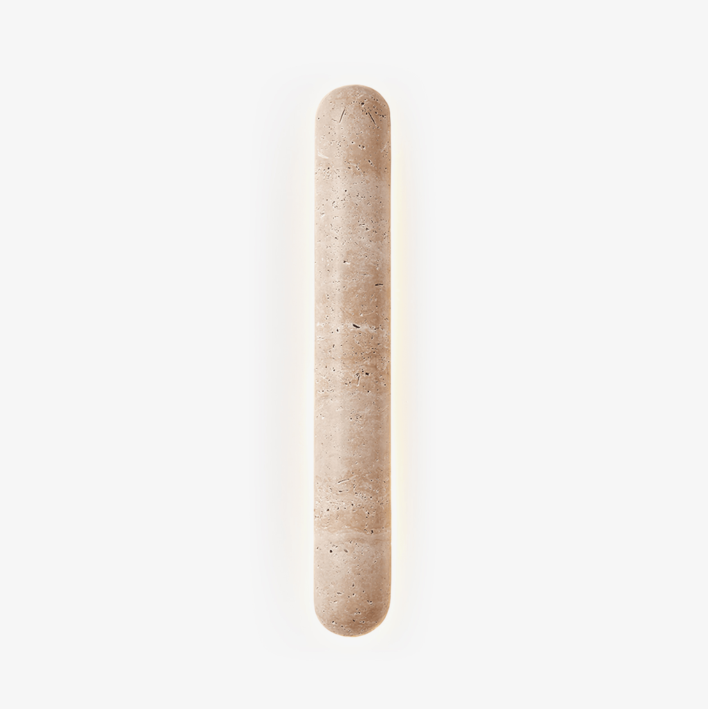 Pill-shaped travertine wall light with a soft halo behind it, this Clérachic sconce on a plain white backdrop.