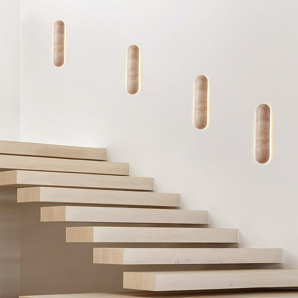 Four Clérachic wall lights stepping up a white wall above a staircase of pale floating treads.