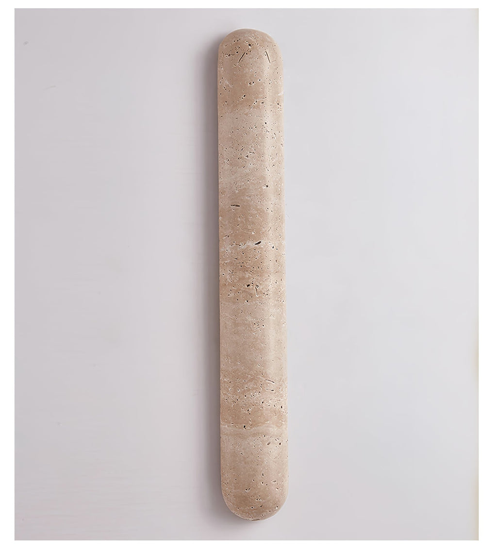 Travertine wall light with a banded beige surface, switched off, this Clérachic sconce on a pale grey wall.